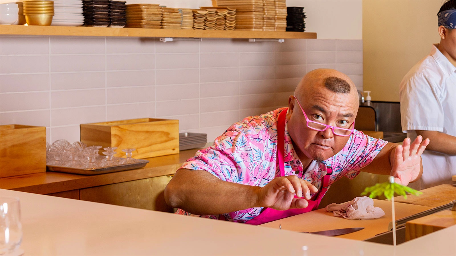 Chef Yoshi Katsuyama crouching behind the sushi counter at Aya Sushi.